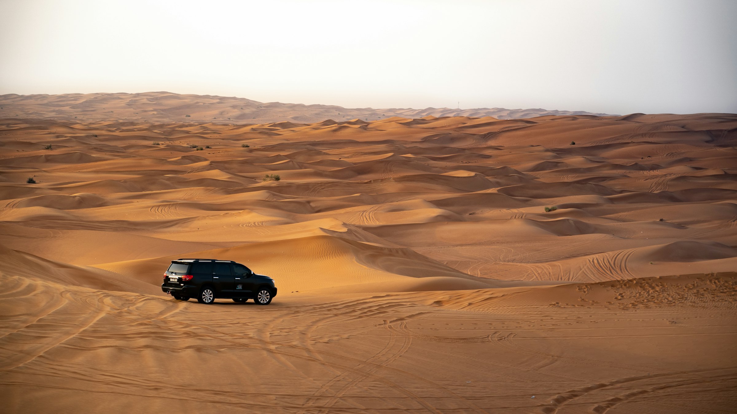Car crossing desert sand dunes